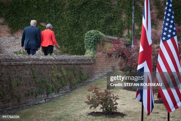 President Donald Trump and Britain's Prime Minister Theresa May walk together following their joint press conference at Chequers, the prime...