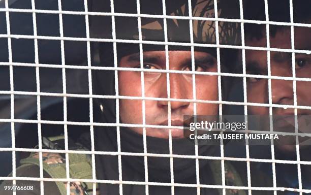 Indian paramilitary troopers looks on from an armoured vehicle during a wreath laying ceremony at a paramilitary camp in Srinagar on July 13, 2018. -...