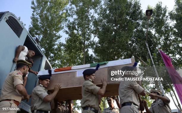 Indian paramilitary troopers carry a coffin with the body of a slain colleague during a wreath laying ceremony at a paramilitary camp in Srinagar on...