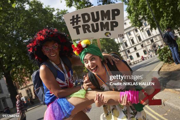 Demonstrators pose for a photograph in Parliament Square as protesters against the UK visit of US President Donald Trump take part in a march and...