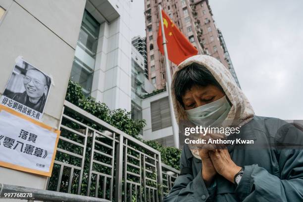 Protester prays in front of a portrait of Liu Xiaobo outside of the Chinese liaison office on July 13, 2018 in Hong Kong, Hong Kong. July 13 marks...