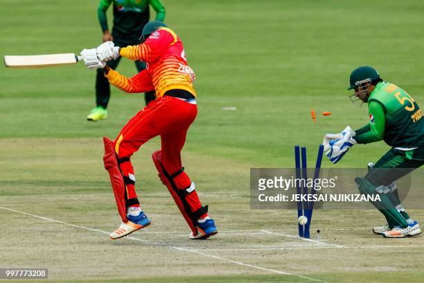 Zimbabwe's batsman Blessing Muzarabani is bowled as Pakistan's wicketkeeper Sarfraz Ahmed looks on during the first one day international cricket...