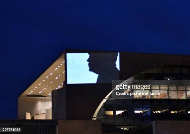 The silhouette of German Chancellor Angela Merkel is being projected onto a wall of the German Chancellery in Berlin, Germany, 3 August 2017....