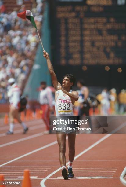 Mexican race walker Ernesto Canto waves his national flag after finishing in 10th place in the Men's 50 kilometres walk event at the 1984 Summer...