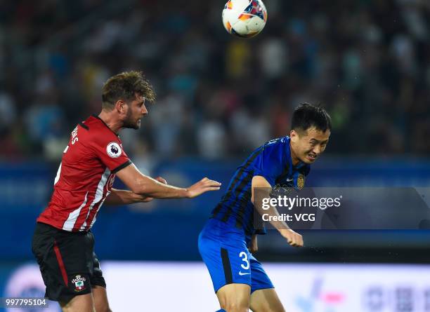 Tian Yinong of Jiangsu Suning and Jack Stephens of Southampton compete for the ball during the 2018 Clubs Super Cup match between Southampton FC and...