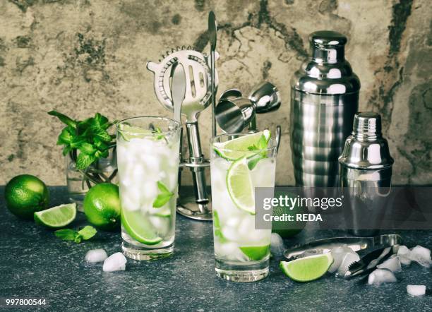 Mojito cocktail with lime and mint in glass on a stone table. Bar tools and ingredients for cocktail. Photo by: Anjelika Gretskaia/REDA/Universal...