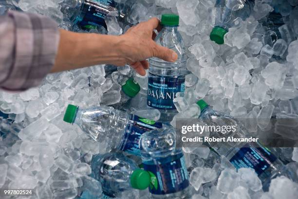 Tub filled with ice and plastic bottles of Dasani purified bottled water being given away at a Fourth of July holiday event in Santa Fe, New Mexico....