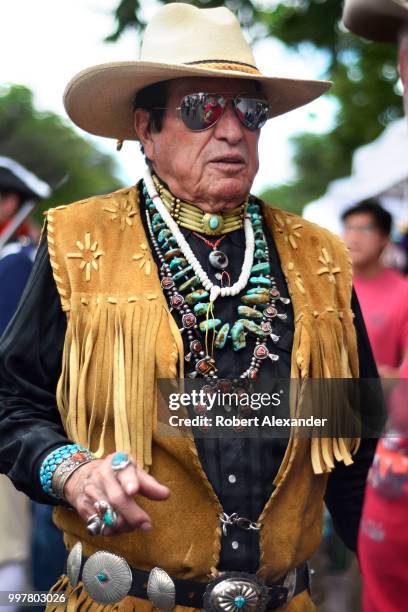 Man wearing Native-American jewelry and western clothing talks with friends in Santa Fe, New Mexico.
