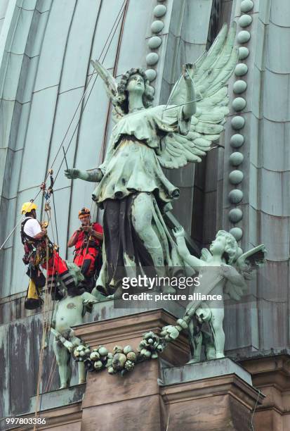 Professional climbers mount a triangle rod onto a copper angel on the roof of the Berlin Cathedral in Berlin, Germany, 3 August 2017. The angle had...