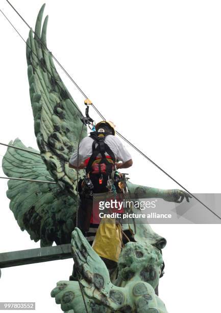 Professional climbers mount a triangle rod onto a copper angel on the roof of the Berlin Cathedral in Berlin, Germany, 3 August 2017. The angle had...