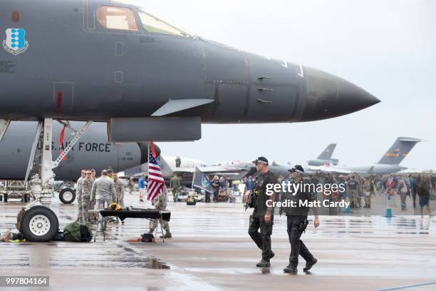 Armed police officers walk past aircraft on the static display at the Royal International Air Tattoo at RAF Fairford on July 13, 2018 in...