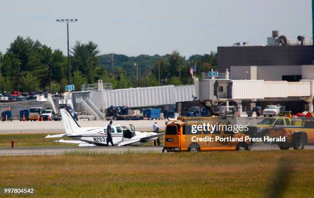 Twin-engine plane with two people aboard landed on its belly at Portland International Jetport on Thursday, causing all runways to close.