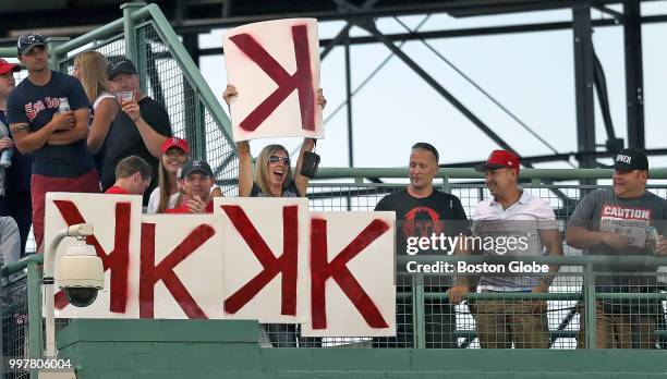 Fan above the centerfield wall holds up a "K" card to add to the lineup after another strikeout by Boston Red Sox pitcher Chris Sale. The Boston Red...
