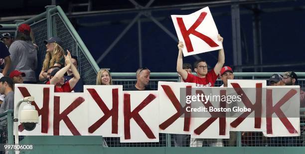 Fan above the centerfield wall holds up a "K" card to add to the lineup after another strikeout by Boston Red Sox pitcher Chris Sale. The Boston Red...