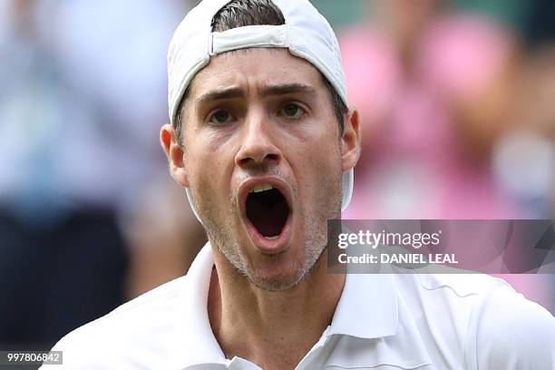 Player John Isner reacts after breaking serve against South Africa's Kevin Anderson in the fourth set during their men's singles semi-final match on...