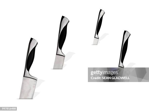 four kitchen knives sticking into white background - stab stockfoto's en -beelden