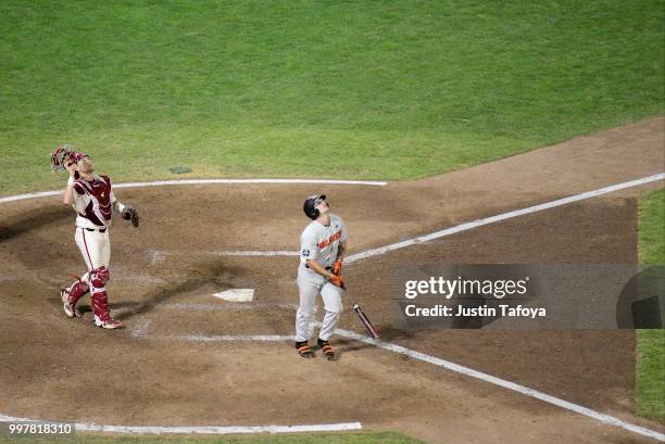 Cadyn Grenier of the Oregon State Beavers and Grant Koch of the Arkansas Razorbacks watch a foul ball that could've been the winning out for the...