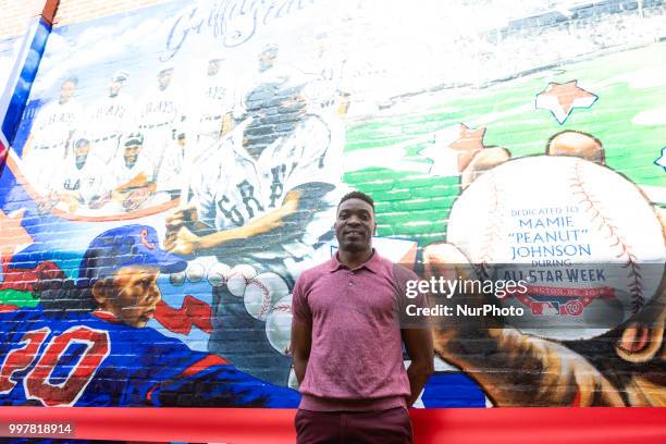 Artist Aniekan Udofia stands in front of the mural he created for Major League Baseball , to honor Negro League Baseball and players, Mamie Peanut...