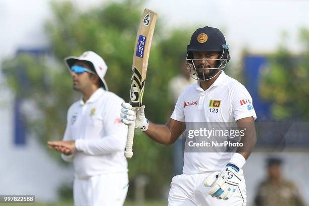 Sri Lankan cricketer Dimuth Karunaratne celebrates after scoring 50 runs during the 2nd day's play in the first Test cricket match between Sri Lanka...