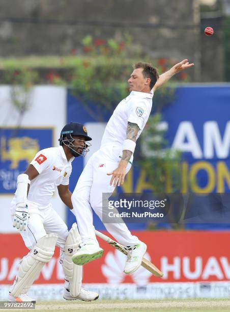 South African cricketer Dale Steyn leaps in the air in an attempt to complete a catch as Sri Lankan cricketer Dimuth Karunarathne looks on during the...