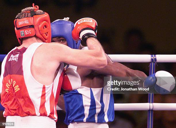 Yohason Martinez of Cuba exchanges blows with opponent Grigore Rasco of Romania during the 81 kg Gold Medal bout held at the South Bank Convention...