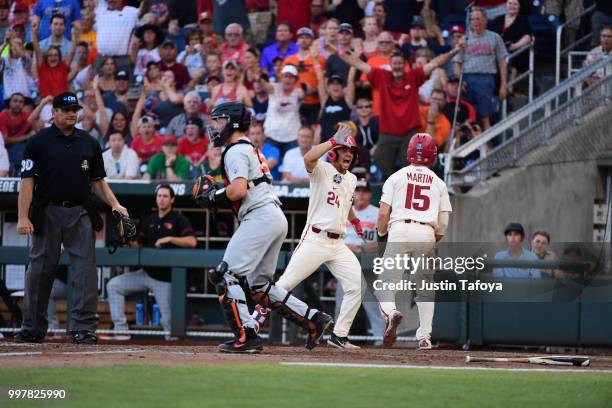 Casey Martin and Dominic Fletcher of the Arkansas Razorbacks celebrate a scored run against the Oregon State Beavers during the Division I Men's...