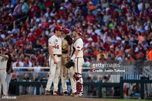 Barrett Loseke, Grant Koch and Carson Shaddy of the Arkansas Razorbacks meet on the mound as they take on the Oregon State Beavers during the...
