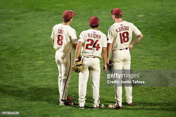 Eric Cole, Dominic Fletcher and Heston Kjerstad of the Arkansas Razorbacks meet during a pitching change as they take on the Oregon State Beavers...