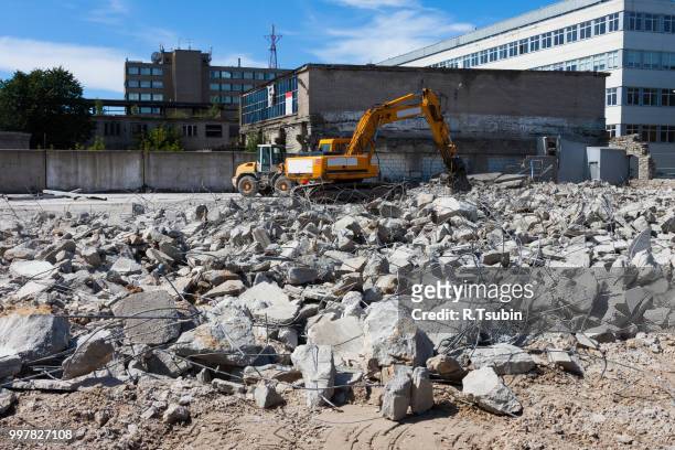 a digger demolishing houses for reconstruction - demolish foto e immagini stock