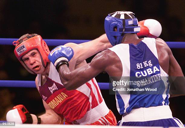 Yohason Martinez of Cuba exchanges blows with opponent Grigore Rasco of Romania during the 81 kg Gold Medal bout held at the South Bank Convention...