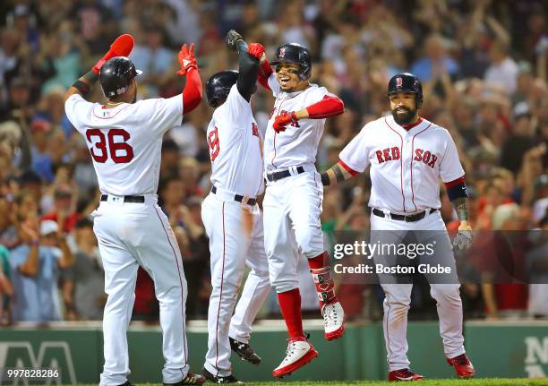 Boston Red Sox player Mookie Betts, second from right, celebrates his fourth inning grand slam at home plate with, from left, teammates Eduardo...