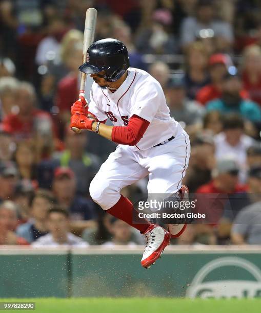 Boston Red Sox player Mookie Betts jumps out of the way of a low seventh inning pitch that hit the dirt before home plate. The Boston Red Sox host...