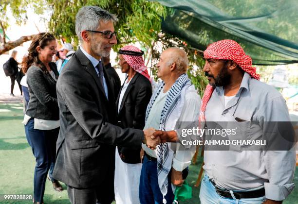 Pierre Cochard , French Consul General to Jerusalem, shakes hands with Palestinian men during his visit to the Bedouin village of Khan al-Ahmar, east...