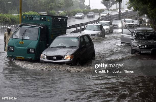 Vehicles wade through the water logged road near Nizamuddin during the heavy rain, on July 13, 2018 in New Delhi, India. The heavy rains came as a...