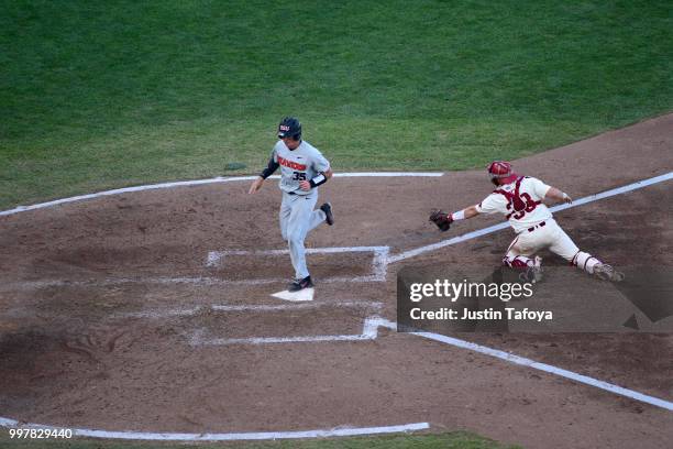 Adley Rutschman of the Oregon State Beavers avoids a tag from Grant Koch of the Arkansas Razorbacks during the Division I Men's Baseball Championship...