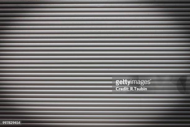 dirty metal roller shutter door as a background - iron roll stock pictures, royalty-free photos & images