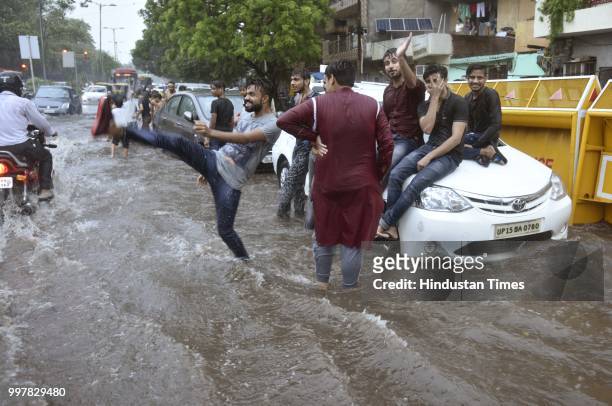 Poeple seen playing on a water-logged road due to heavy rainfall, at Ranjit Flyover, on July 13, 2018 in New Delhi, India. The heavy rains came as a...