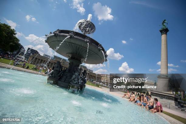 July 2018, Stuttgart, Germany: Students of the College Esslingen cool their legs inside a fountain at the Schloss Plaza. Photo: Marijan Murat/dpa