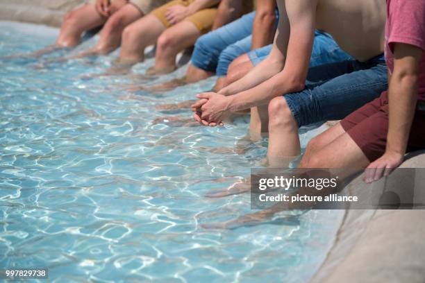 July 2018, Stuttgart, Germany: Students of the College Esslingen cool their legs inside a fountain at the Schloss Plaza. Photo: Marijan Murat/dpa