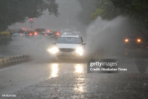 Vehicles wade through the street during heavy rainfall at Tolstoy Marg, on July 13, 2018 in New Delhi, India. The heavy rains came as a respite to...