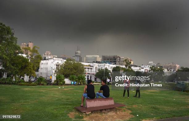 People seen enjoying the showers as rain hits the city, at Connaught Place, on July 13, 2018 in New Delhi, India. The heavy rains came as a respite...