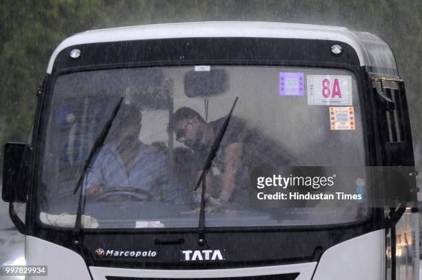 Commuters travel during heavy rainfall near Film City road, on July 13, 2018 in Noida, India. The heavy rains came as a respite to the people of...
