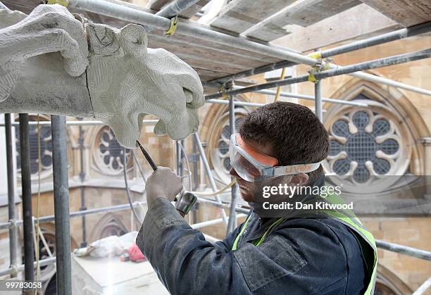 Stone carver Simon Smith puts finishing touches to a gargoyle on Westminster Abbey's Chapter House on April 14, 2010 in London, England. Built in the...