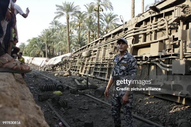 Police officer walks at the scene where a train derailed near Badrasheen, Giza, Egypt, 13 July 2018. At least 55 people were injured as a Health...