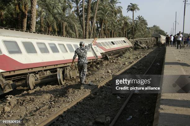Dpatop - A police officer walks at the scene where a train derailed near Badrasheen, Giza, Egypt, 13 July 2018. At least 55 people were injured as a...