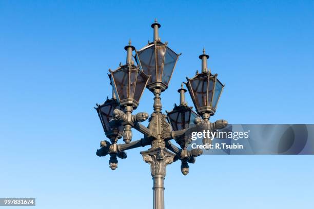 antique frosty lamppost and beautiful snow covered branches against the azure sky - antique lightbulb stockfoto's en -beelden