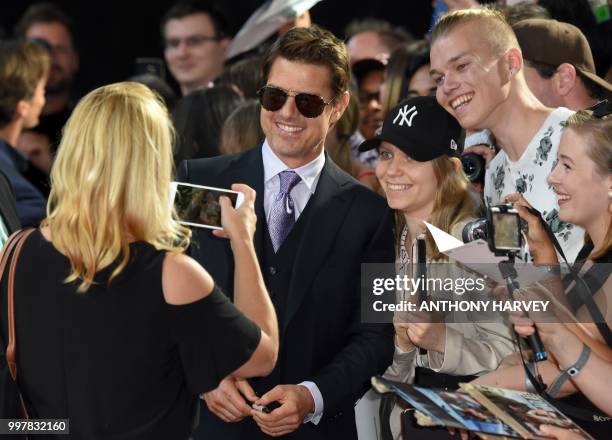 Actor Tom Cruise poses for a photograph with fans as he arrives for the UK premiere of the film Mission: Impossible - Fallout in London on July 13,...