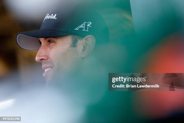 Aric Almirola, driver of the Smithfield Ford, stands in the garage area during practice for the Monster Energy NASCAR Cup Series Quaker State 400...