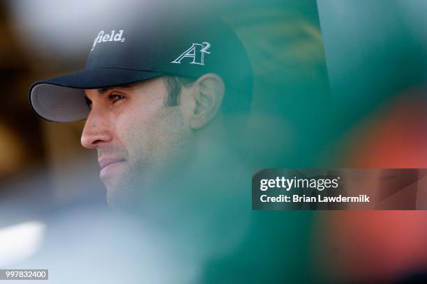 Aric Almirola, driver of the Smithfield Ford, stands in the garage area during practice for the Monster Energy NASCAR Cup Series Quaker State 400...