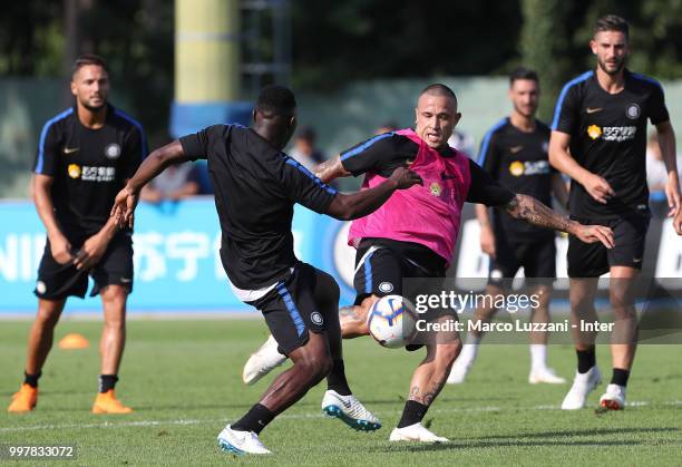 Radja Nainggolan is challenged by Kwadwo Asamoah during the FC Internazionale training camp at the club's training ground Suning Training Center in...